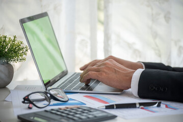 Closeup businessman hands working use laptop finance business document reading report paperwork...