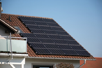 Solar panels on the roof of a house with red tiles