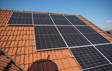 Solar panels on the roof of a house with red tiles