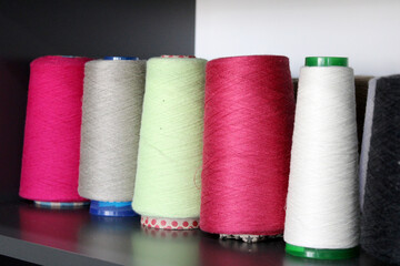Colorful sewing threads wound on a thread spool. textile