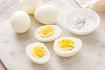 Boiled eggs peeled and cut in half with salt and pepper - 768332374