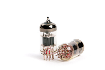A 12AX7 style audio apmlifier vacuum tube in front of an out of focus loudspeaker in the background isolated on white