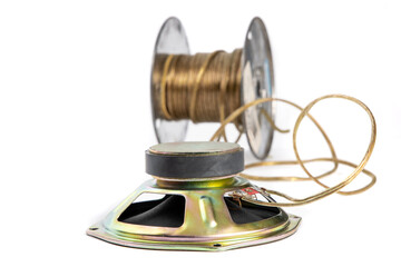 An upside down loud speaker showing connected to a roll of speaker wire out of focus in the...