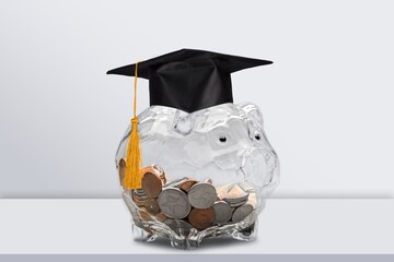Graduation hat on piggy bank with coins