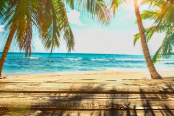 Wooden old table of free space for your decoration. Summer beach landscape with palms and ocean....