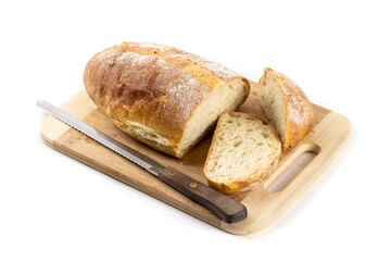 A whole loaf of artisanal crusty bread with a slice cut off on a wooden cutting board isolated on...