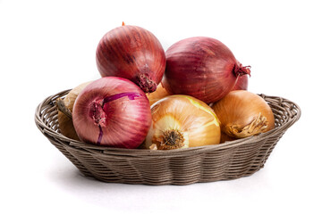 Red and yellow cooking onions in a market stall basket isolated on white