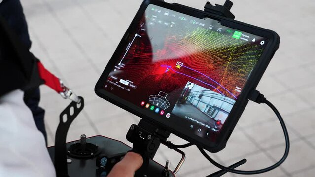 Drone operator with remote control and wide tablet screen with lidar sensor map