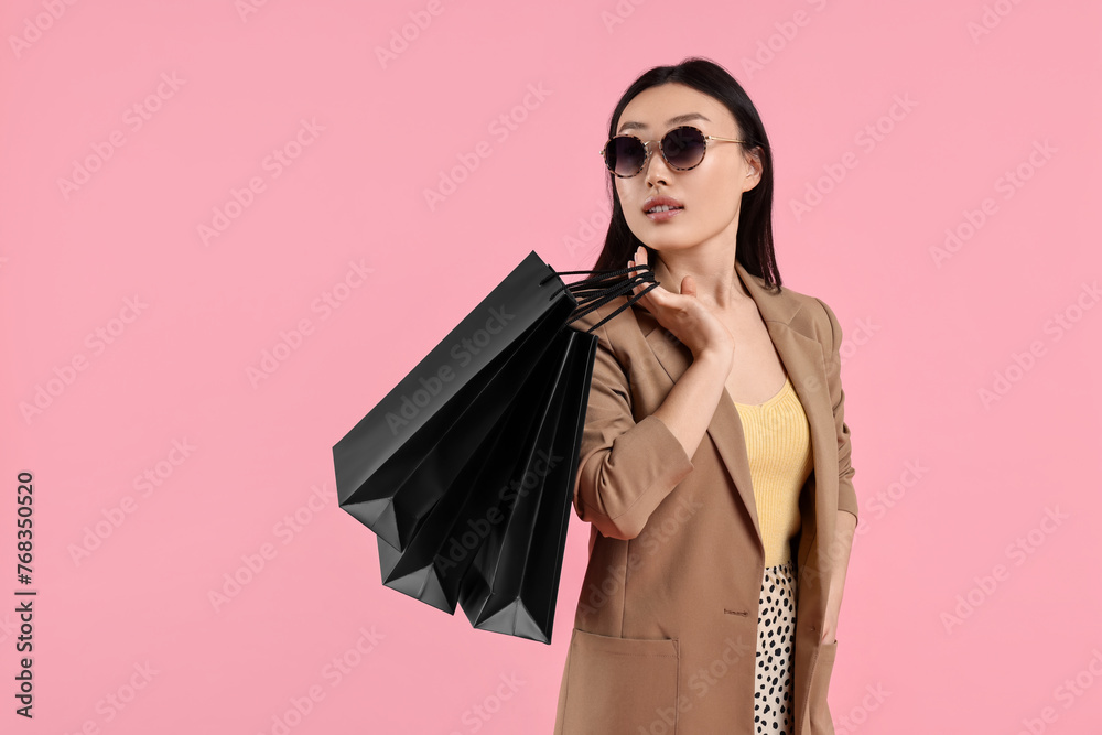 Canvas Prints Beautiful woman with shopping bags on pink background. Space for text