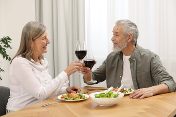 Obraz na płótnie Canvas Happy senior couple having romantic dinner at home