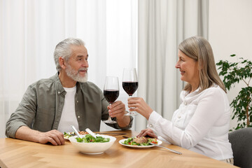 Happy senior couple having romantic dinner at home
