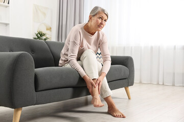 Arthritis symptoms. Woman suffering from pain in leg at home