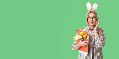 Happy businesswoman with Easter bunny ears, folder and flowers on green background with space for...