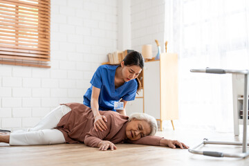 Asian caregiver help senior female from falling on the ground at home. 