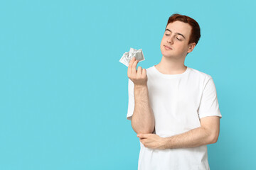 Young man with condoms on blue background. Safe sex concept