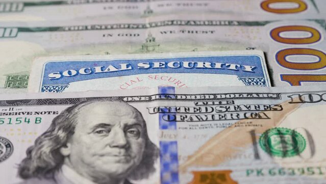 Social security card with one hundred dollar bills