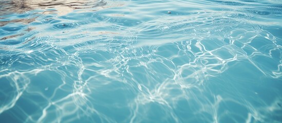 A close up of a person swimming in the azure liquid of a swimming pool, creating mesmerizing patterns in the electric blue water