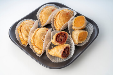 Curry puff on black plate on white background, Curry puff pastry on white background.