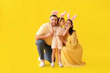 Happy family in Easter bunny ears on yellow background