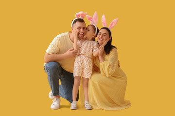 Happy family in Easter bunny ears on yellow background - obrazy, fototapety, plakaty