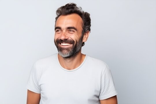 Portrait of a handsome man smiling at the camera on grey background