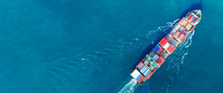 Fototapeta Aerial view of cargo ship with contrail in the ocean sea ship carrying container and running from container international port smart freight shipping by ship service