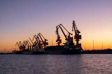 Gantry crane and cargo ship in the evening