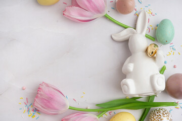 Composition with tulips, color eggs and bunny figure on light background, closeup