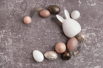 Easter eggs and bunny figure on grey background