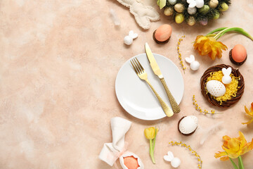 Table setting with Easter eggs, beautiful tulips and mimosa flowers on beige background
