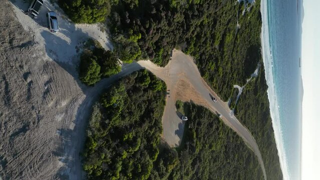 Vehicle driving along panoramic road near Wylie Bay Rock beach, Esperance area in Western Australia. Aerial drone view and vertical format. 