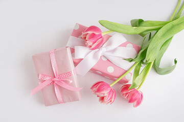Obraz na płótnie Canvas Gift boxes with beautiful tulip flowers on white background
