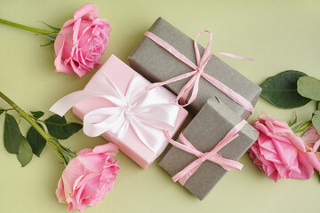 Gift boxes and beautiful roses on green background
