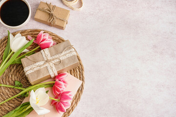 Gift boxes with beautiful tulips and cup of coffee on white background