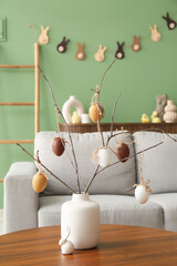 Ceramic vase with Easter color eggs in interior of modern living room