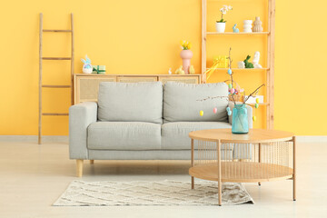 Sofa and table in stylish living room decorated for Easter celebration