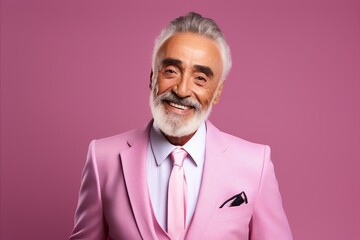 Handsome mature man in pink suit and tie on pink background