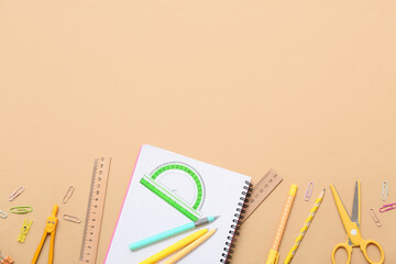 Notebook with protractor and pens on beige background. Top view