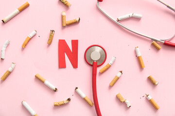 Cigarette butts, word NO made of paper and stethoscope on pink background. Stop smoking concept.