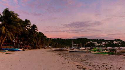 Beach Sunset Serenity. A tranquil beach scene at dusk with boats silhouetted against the horizon. Nature’s beauty in perfect harmony.