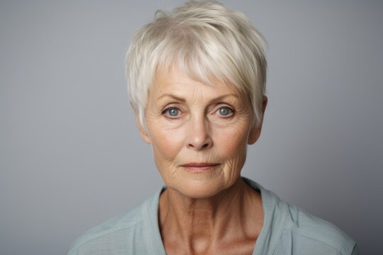 Portrait of a senior woman looking at the camera against a grey background