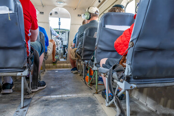 Selective focus floor level view inside a small private tour plane with passengers. 