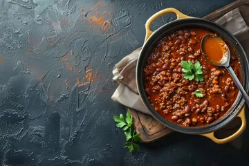 Keuken spatwand met foto A bowl of chili filled with hearty ingredients, topped with a spoon ready to be enjoyed © Ilia Nesolenyi