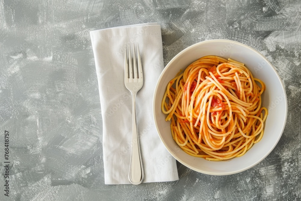 Wall mural A bowl of spaghetti and a fork placed on a wooden table