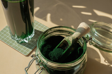 Natural organic green spirulina algae powder drink on neutral beige background. Chlorella seaweed...