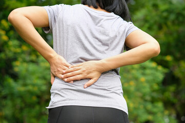woman's hand he is caught at the waist and her back is painful at the back in the room. health...