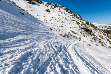 Sceneria roztaczająca się ze szlaku prowadzącego z Hali Gąsienicowej, nad Czarny Staw Gąsienicowy w Tatrach Wysokich. Zdjęcie wykonane w słoneczny, zimowy dzień. - obrazy, fototapety, plakaty