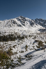 Sceneria roztaczająca się ze szlaku prowadzącego z Hali Gąsienicowej, nad Czarny Staw Gąsienicowy w Tatrach Wysokich. Zdjęcie wykonane w słoneczny, zimowy dzień. - obrazy, fototapety, plakaty