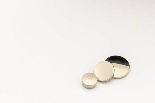 Three circular lithium batteries of different sizes on a white background. 