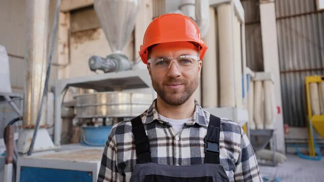 Portrait of worker in uniform near production line on pvc factory